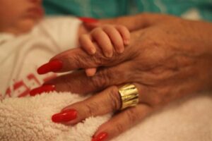 יד של תינוק אוחזת ביד של סבתא